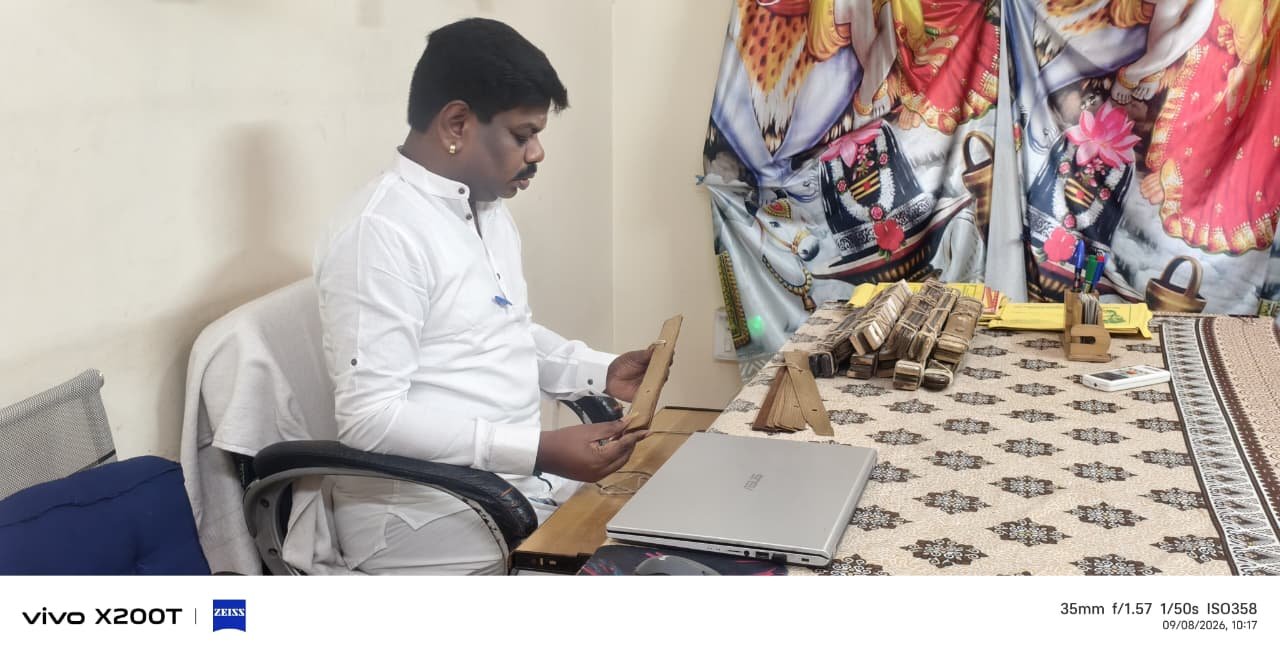 Guruji closely studying a palm leaf