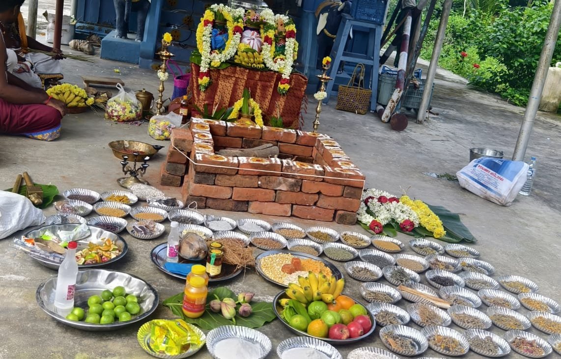 Navadhanyam grains arranged around a brick homa kundam
